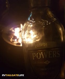 Powers whiskey next to the campfire!