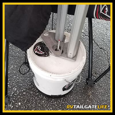 DIY tent weights from small paint cans and Atlanta Falcons logos.