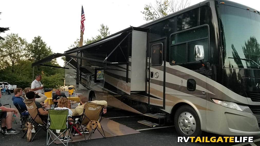 RV tailgating - a Tiffin Class A motorhome hosts a tailgate with people watching games around the outside TV