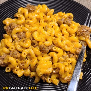 One pot hamburger helper pasta with ground beef and a fork on a black plate